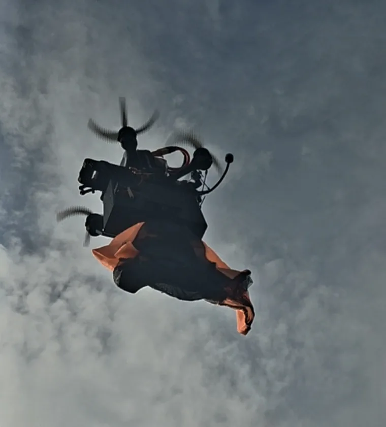 Multirotor in flight releasing a store from a servo dropper.