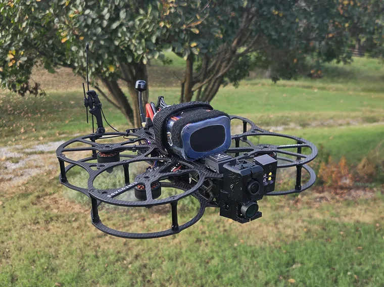 Ducted multirotor with a gimballed camera and a light module.